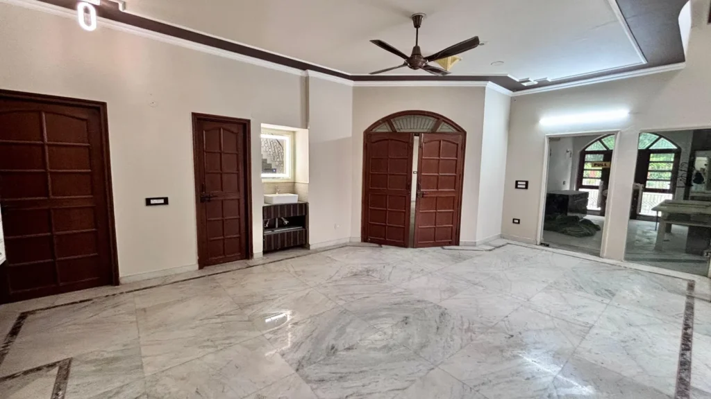 Family lounge inside Residential Kothi in Noida Sector 56 with marble flooring and large open layout.
