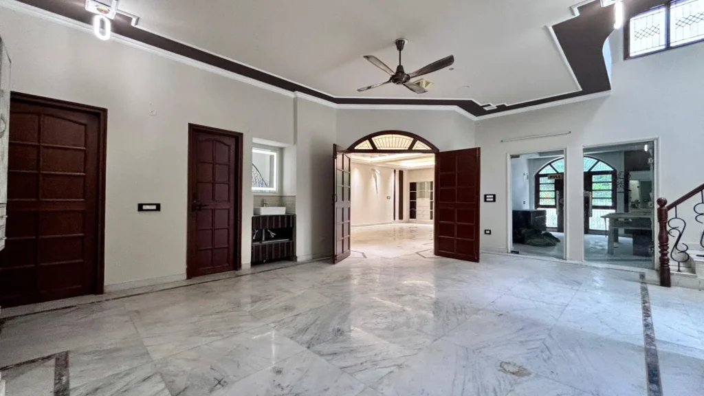 Residential Kothi in Noida Sector 56 spacious living room with premium marble flooring and designer false ceiling.