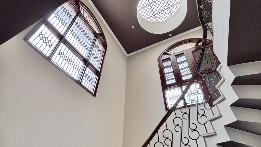 Grand staircase with double-height ceiling inside Residential Kothi in Noida Sector 56.